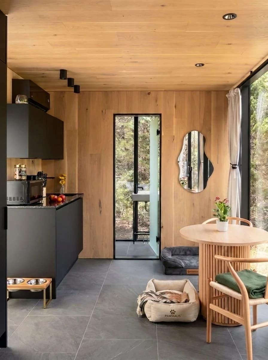 Mirror House interior with kitchenette, dining area, dog bed, and feeding station